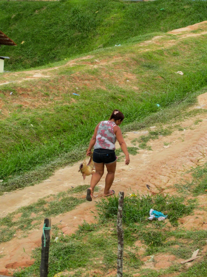 A lady struggling up the hill with her giant fish